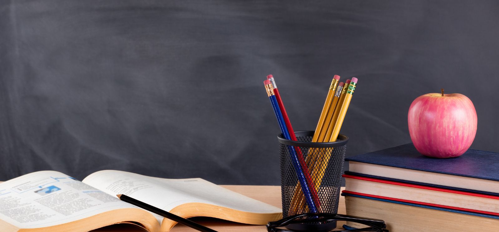 Chalkboard with books and pencils on desk