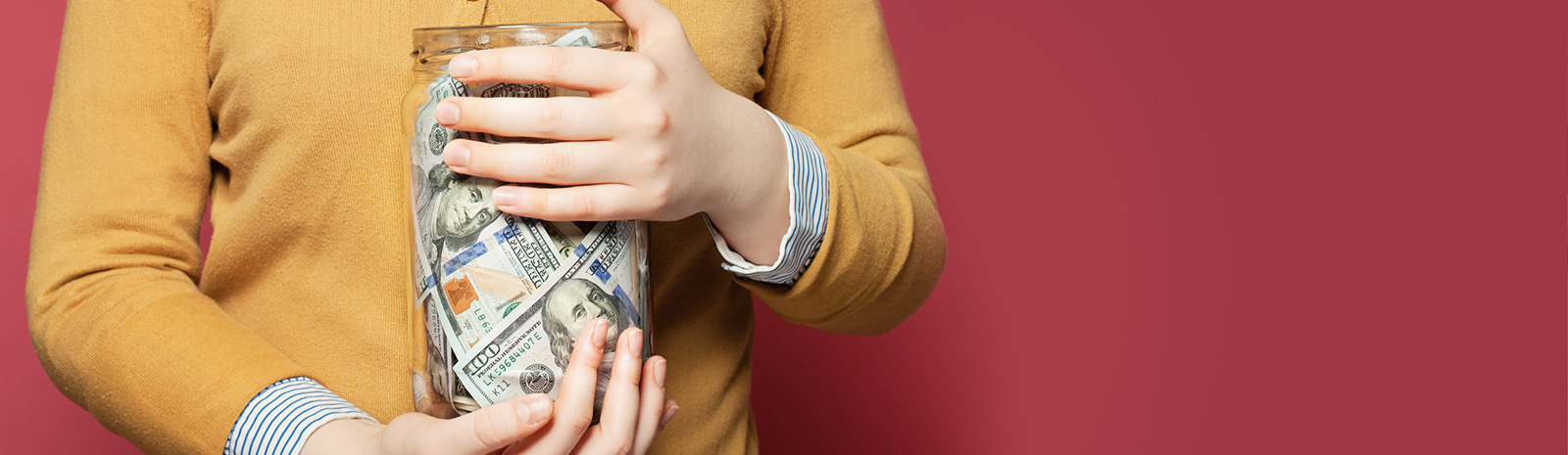 Person holding jar of money