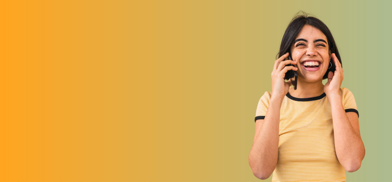 Girl laughing and holding a cell phone to her ear