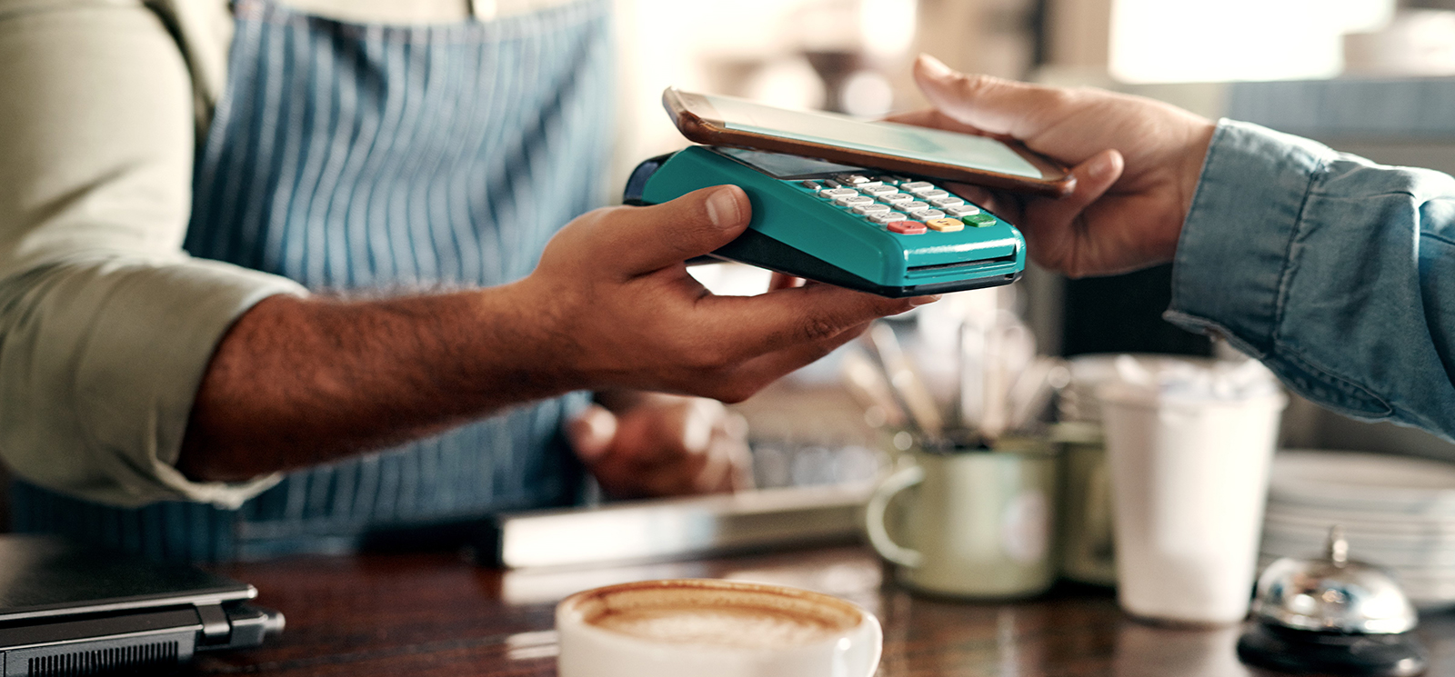Person paying with digital wallet at cafe