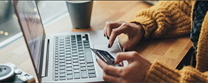 woman at computer holding credit card