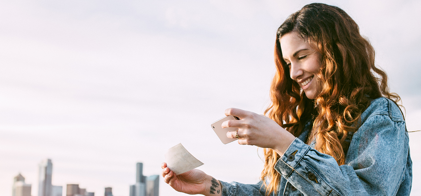 Girl taking a picture of a check with her cell phone.